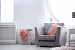 Comfortable armchair with fuzzy pillow in stylish room interior