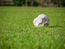 Old Leak Football/soccer Ball Abandoned On Green Grass Field. Concept Of Sadness, Hopeless And Loneliness.