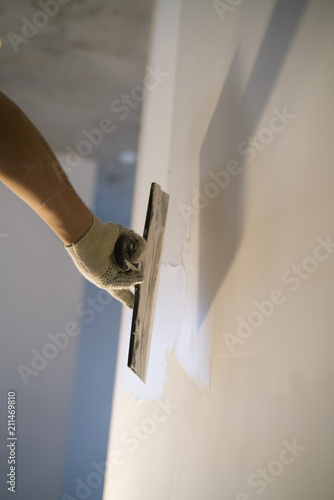 Fotografía worker applying putty on the wall with putty knife