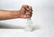 hand squashing empty plastic bottle
