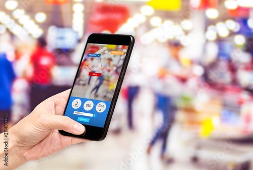 Fotografía Hand hold mobile phone and using augmented reality ( AR ) app for see promotion sale in supermarket store,Digital lifestyle Technology concept