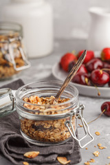 Wall Mural - Homemade oat granola in glass jars with cherry and milk. Healthy food concept.