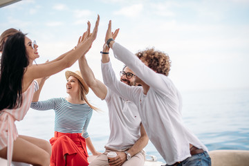 All together we done it! Conception of successful teambuilding. Five happy students putting their hands up together, celebrating their successful exams