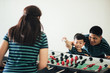 © ic36006 - Happy asian family playing table football together in sport club.
