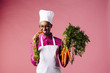© Carlos David - Smiling cook holding carrots, biting into one
