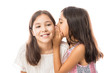 © AntonioDiaz - Younger sister whispering gossip to her elder sister on white background