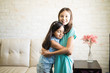 © AntonioDiaz - Small sisters embracing each other at living room