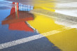 Reflections on wet asphalt. Red and yellow spots. Daytime.