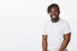 © Cookie Studio - Indoor shot of friendly relaxed dark-skinned guy with beard and moustache, smiling broadly while standing in casual white t-shirt, being happy to share positive moments with close friends