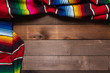 A mexican serape blanket on a wooden plank background