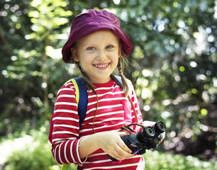 Wall Mural - Little girl using binoculars in the forest