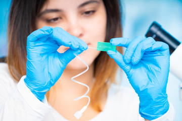 Wall Mural - technician girl with microfluidic device LOC in microbiological lab