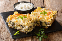 Delicious Lasagna With Chicken Breast, Porcini Mushrooms, Cheese, Herbs And Bechamel Sauce Close-up On A Slate Plate On A Wooden Table. Horizontal