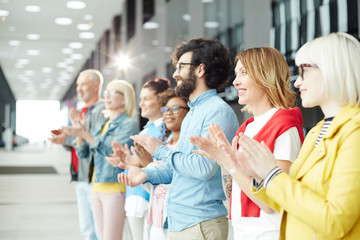 Wall Mural - Row of satisfied people clapping their hands to coach or speaker after presentation