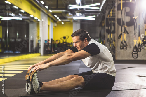 Full Length Side View Orderly Man Doing Stretching While Sitting Full Length Side View Orderly Man Doing Stretching While Sitting