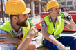 © Kzenon - Two young workers smiling, while drinking a cold alcoholic or non-alcoholic beer during break at work on the construction site in a sunny day of summer