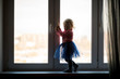 © AnastasiaKharichkina - little girl standing by the window