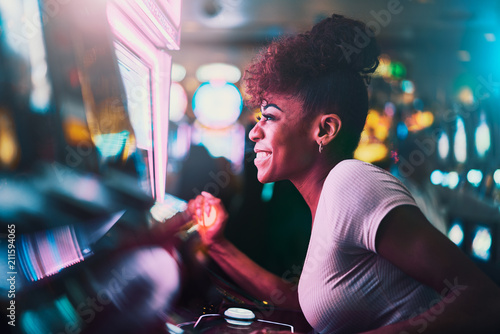 Cuadros en Lienzo happy woman gambling at casino playing slot machine