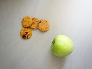 Four cookies and a green apple for a healthy breakfast