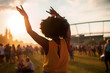 © leszekglasner - Young African American woman dancing at summer holi festival, back view