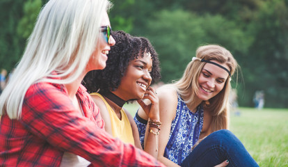 Wall Mural - Group of friends having fun together sitting on grass