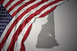 waving national flag of united states of america on a gray new hampshire state map background.