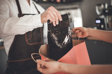 Professional Barista Giving Coffee Pack Into Shopping Bag For Customer At Cafe
