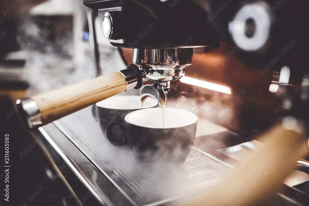 Espresso poruing from coffee machine at cafe - obrazy, fototapety, plakaty 