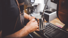 Barista Steaming Milk Using Coffee Machine, Close Up View On Hands During Preparation