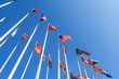 Bottom view of a rows of flags of different countries of the world, flutters in the wind, against a clear blue sky with copy space