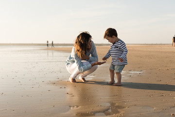 Wall Mural - Mother at the beach with toddler