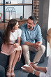 © LIGHTFIELD STUDIOS - smiling couple looking at each other and sitting on therapy session by female counselor in office