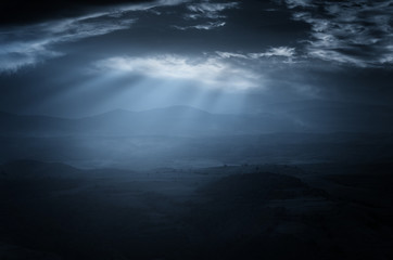 dark sky with moonlight piercing through storm clouds, dark landscape background