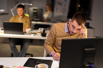 Wall Mural - business, deadline and technology concept - man with computer working at night office