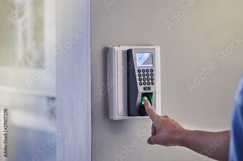 Fotografía Yong man or woman push finger down on the electronic control machine to access the door