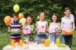 © Syda Productions - holidays, childhood and celebration concept - happy kids with gifts on birthday party at summer garden