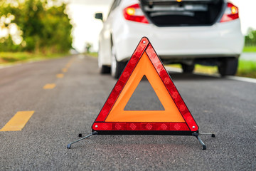 Problems car and a red triangle warning sign on the road