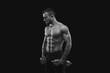 © Prostock-studio - Strong man with dumbbell showing muscular body