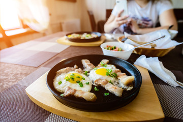 Wall Mural - Delicious fried eggs with bacon in the pan in the cafe, selectiv