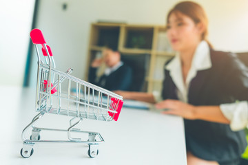 Mini shopping cart in e commerce office, Business women team working in ecom office, Business and Office Concept.