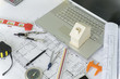 © Somkiat - Model house , calculator, dividers pencil and engineer equipment on architectural blueprint plans background.
