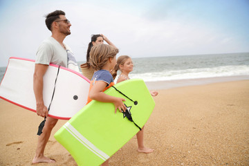 Wall Mural - Family of 4 walking on sandy beach, ocean view