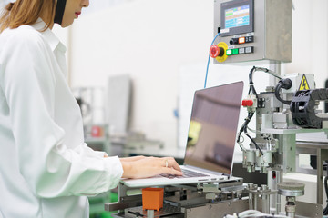 Woman software engineers developing automated robotic in production line, Industry