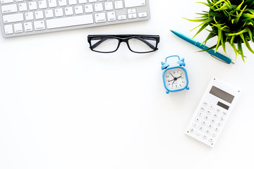 Deadline concept. Alarm clock on office work daesk with computer, glasses, calculator on white background top view space for text