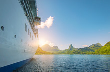 Side View Of Anchored Cruise Ship At Sunset. Mountain Background.