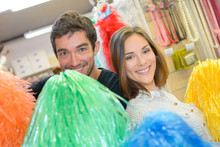 Couple Having Fun With Pompoms At Dressing Up Shop