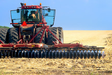 Red Tractor For Harvesting In The Midst Of The Summer Season, Produces Disk Field