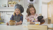 © KONSTANTIN SHISHKIN - Two preschool girls bakers drinks tea