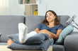 Disabled woman with a plaster foot boring at home