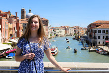 Young Female Tourist Standing In Venice Background, Italy. Concept Of Last Minute Tours To Romantic Europe And Amazing Summer Trip.